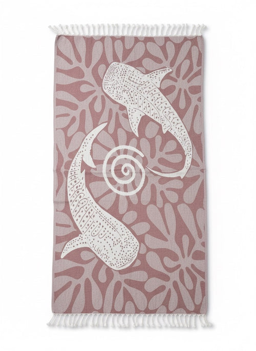Towel with white sea creature pattern on a pink background