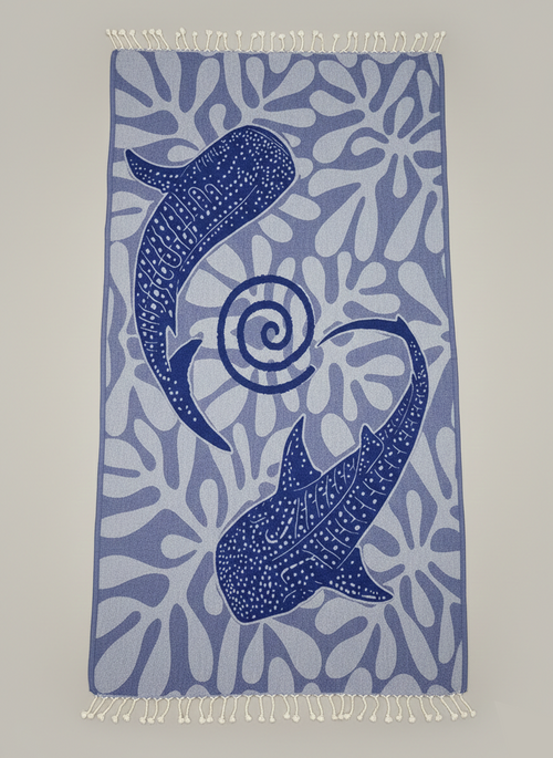 Towel with blue whale design on a light gray background